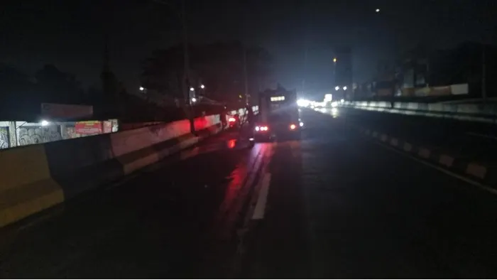 Petugas membersihkan tumpahan oli yang bikin kecelakaan beruntun di Flyover Gaplek, Tangerang Selatan.