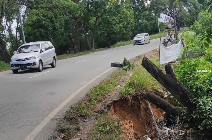 Jalan amblas yang terkikis air hujan terlihat ditepi jalan Yos Sudarsoa.