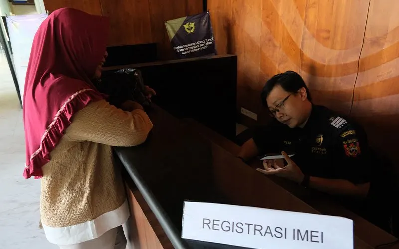 Ilustrasi: Seorang warga mendaftarkan IMEI ponsel yang dibeli di luar negeri.